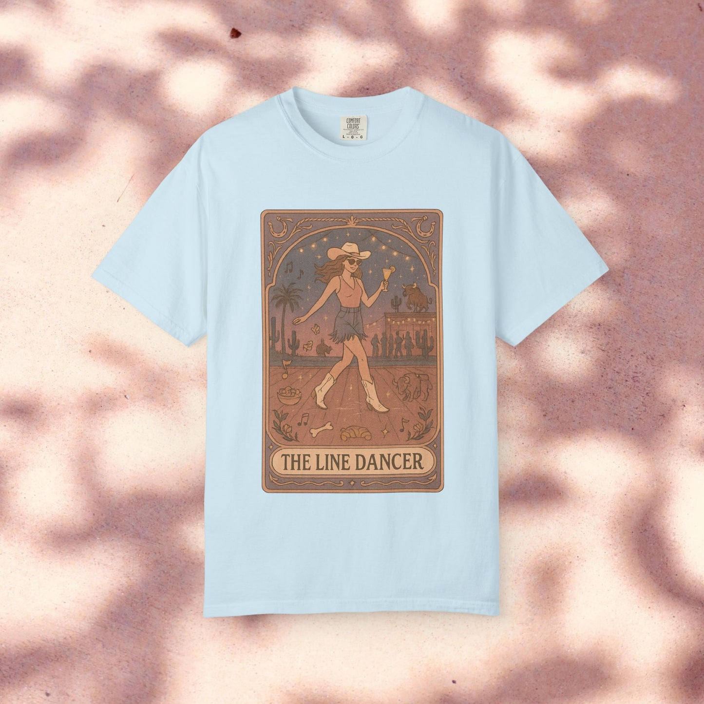 Line Dancer Tarot Tee in light blue, showcasing a distinctive design with a dancer surrounded by an artistic backdrop, crafted from high-quality, ethically made cotton. Sizes range from S-4XL.