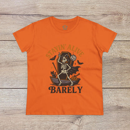 Stayin’ Alive T-Shirt in vibrant orange featuring a playful skeleton design, perfect for Halloween. Unisex softstyle tee ideal for casual wear.