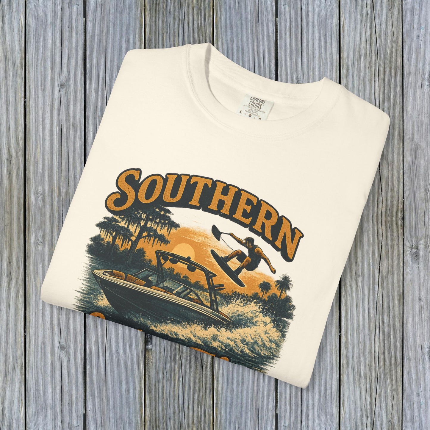 Folded Southern Lake Flow T-Shirt in cream color, crafted from 100% US cotton. A stylish and sustainable choice for outdoor enthusiasts.