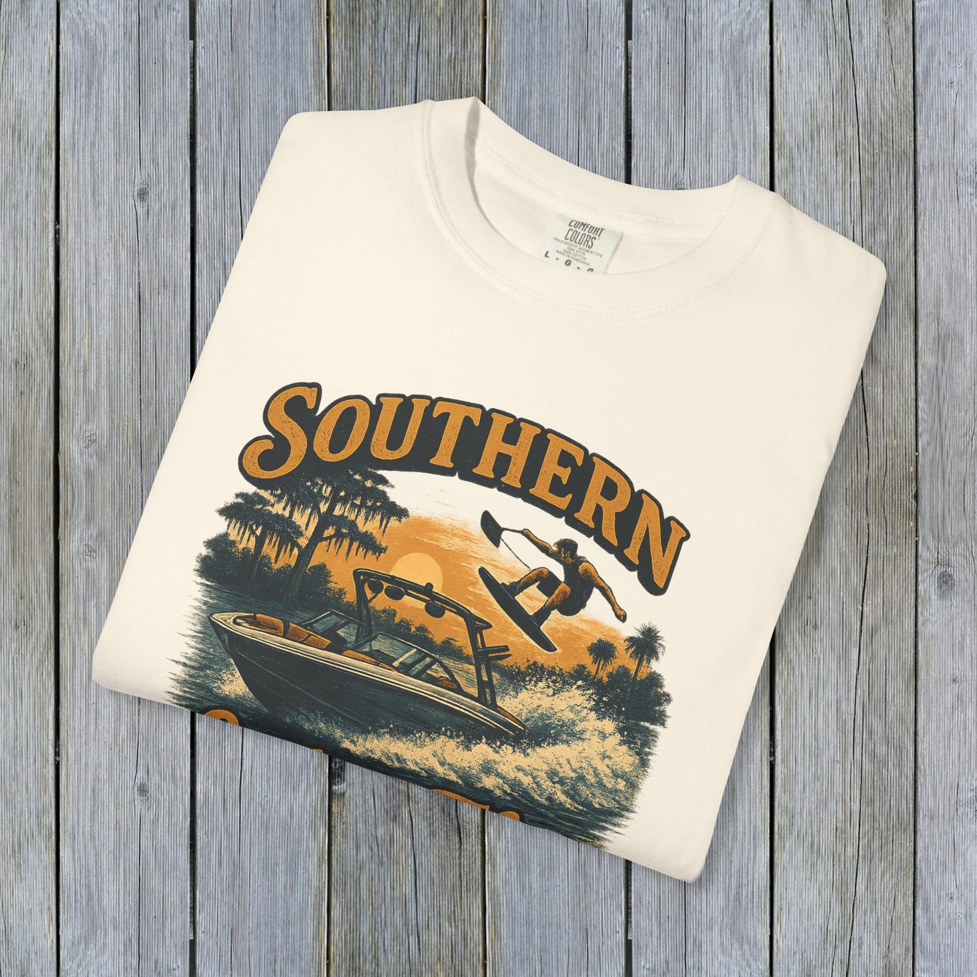 Folded Southern Lake Flow T-Shirt in cream color, crafted from 100% US cotton. A stylish and sustainable choice for outdoor enthusiasts.