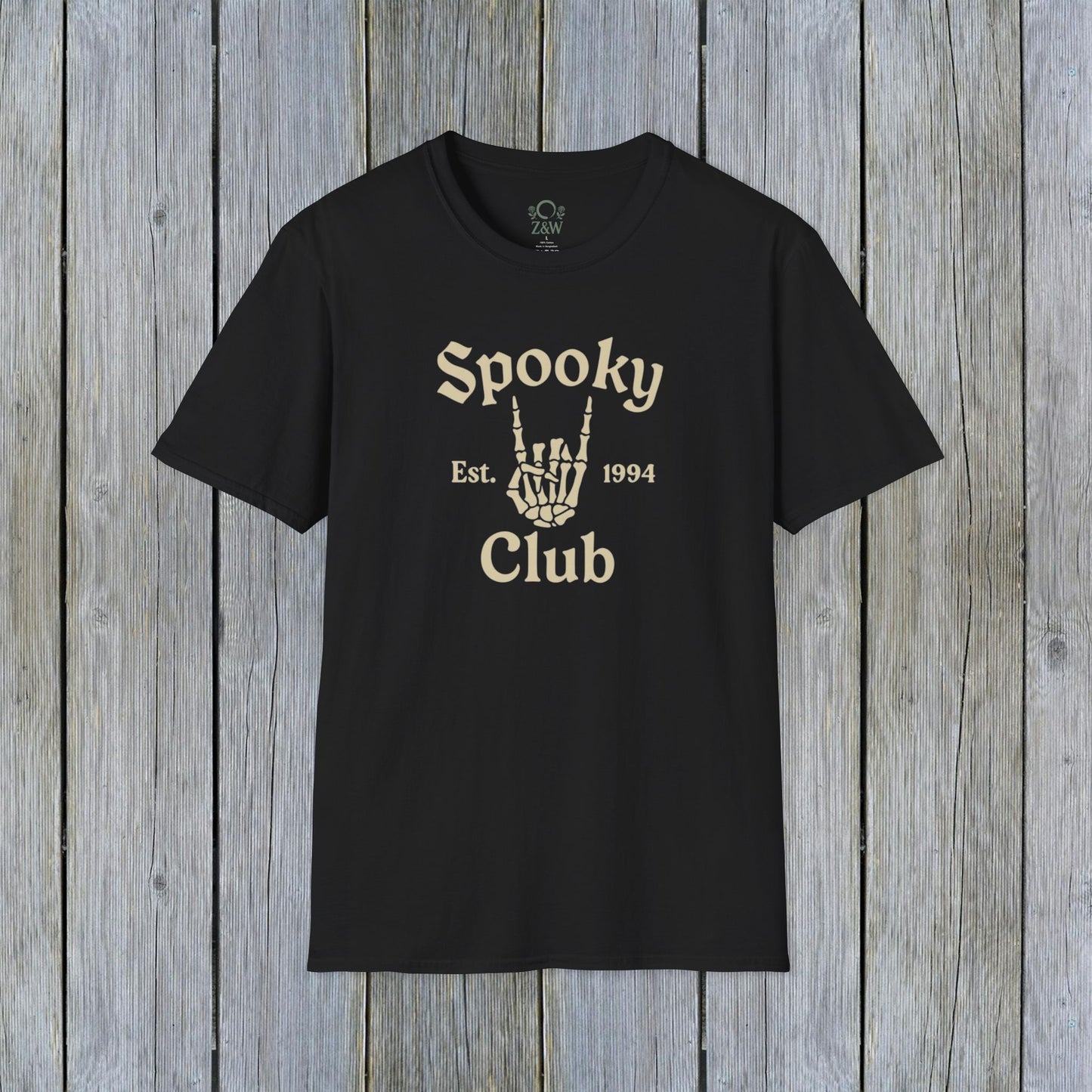 Unisex Spooky Club Tee displayed on a rustic wooden background, featuring a skeleton hand graphic and the text 'Spooky Club Est. 1994' in a stylish font. Durable design crafted from 100% soft cotton, perfect for Halloween enthusiasts.