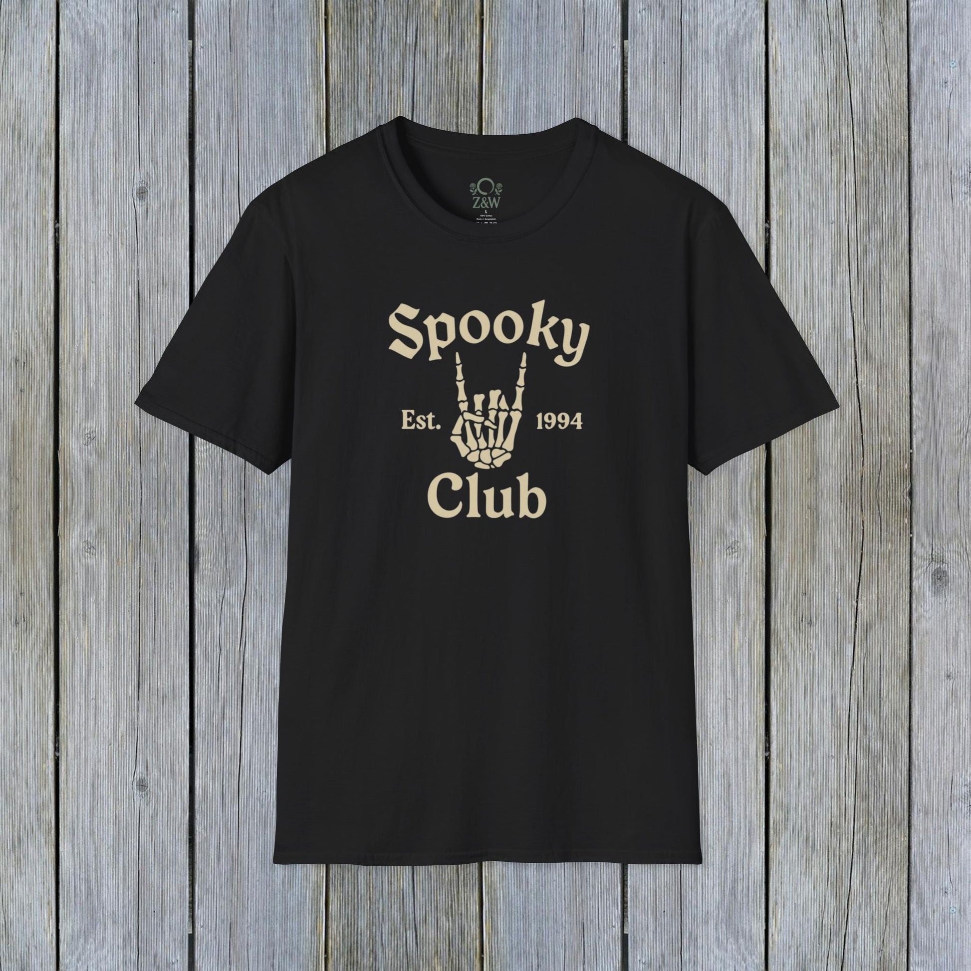 Unisex Spooky Club Tee displayed on a rustic wooden background, featuring a skeleton hand graphic and the text 'Spooky Club Est. 1994' in a stylish font. Durable design crafted from 100% soft cotton, perfect for Halloween enthusiasts.