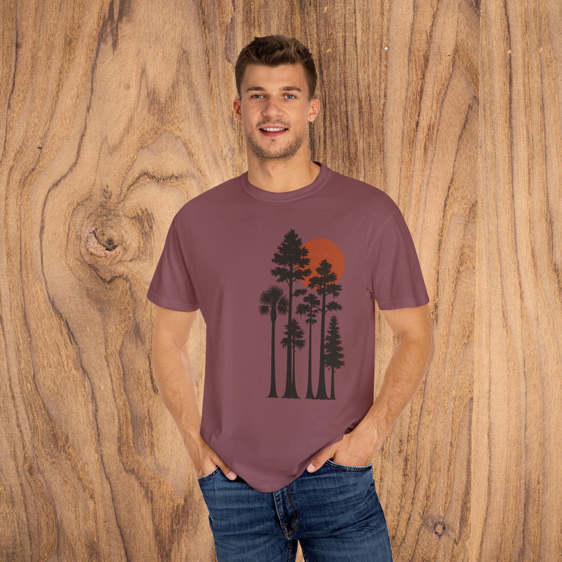 Sunset Trees Unisex T-Shirt model wearing a soft cotton T-shirt in rich color with a sunset and tree design, perfect for casual outings.