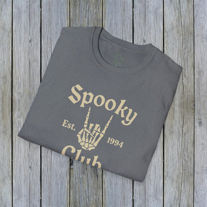 Folded Unisex Spooky Club Tee in heather gray, resting on a rustic wooden surface. The tee features a skeleton hand and 'Spooky Club Est. 1994' text, made from soft 100% cotton for a comfy Halloween wear.
