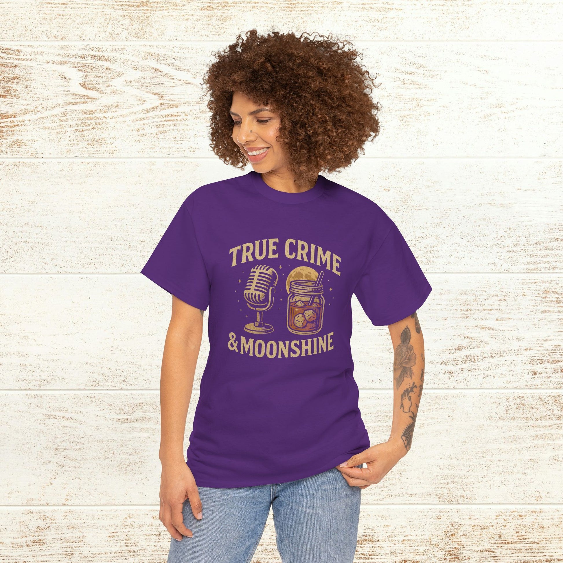 Model wearing True Crime & Moonshine Unisex Graphic Tee in purple, showcasing a unique vintage design for true crime lovers.