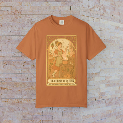 Culinary Queen Tarot Tee in burnt orange color, featuring a vintage-inspired design of a woman cooking with a whimsical background, available in sizes S to 4XL.