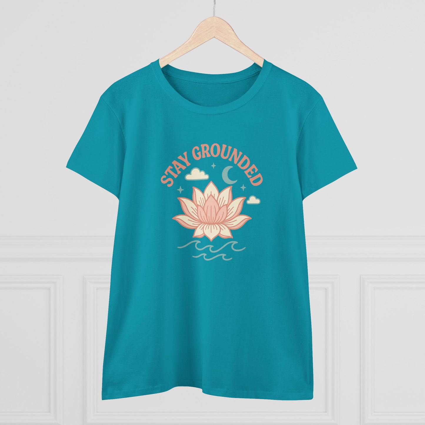 Front view of Stay Grounded Spiritual Tee in turquoise, featuring a lotus design, perfect for summer festivals and casual outings, hanging on a wooden hanger.