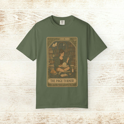 Page Turner Tarot Tee - Soft Cotton T-Shirt in earthy green, showcasing a delightful design of a character with tarot cards and books, great for creating a cozy reading vibe.