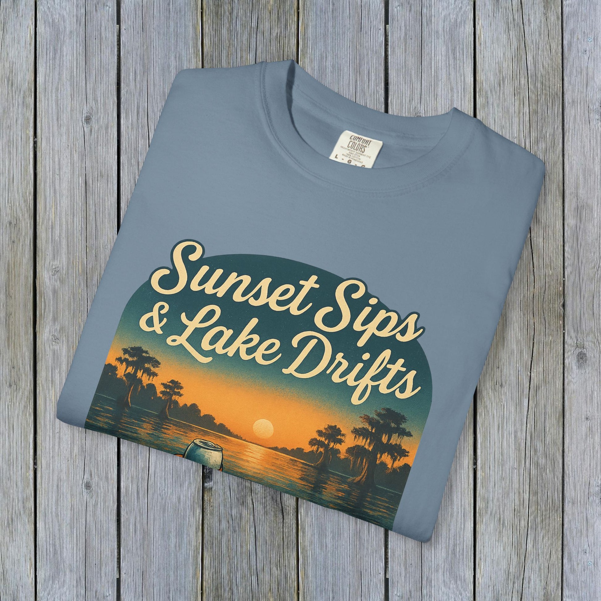Lake Drifts T-Shirt with sunset graphic in soft blue color, highlighting the unique and durable 100% US cotton.