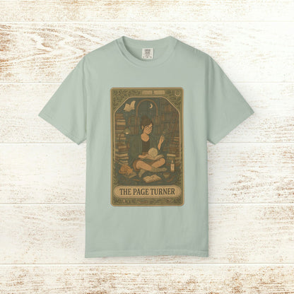 Page Turner Tarot Tee in light green, depicting a charming scene of an individual reading in a book-filled space, designed for comfort and eco-friendliness, available in sizes S to 4XL.