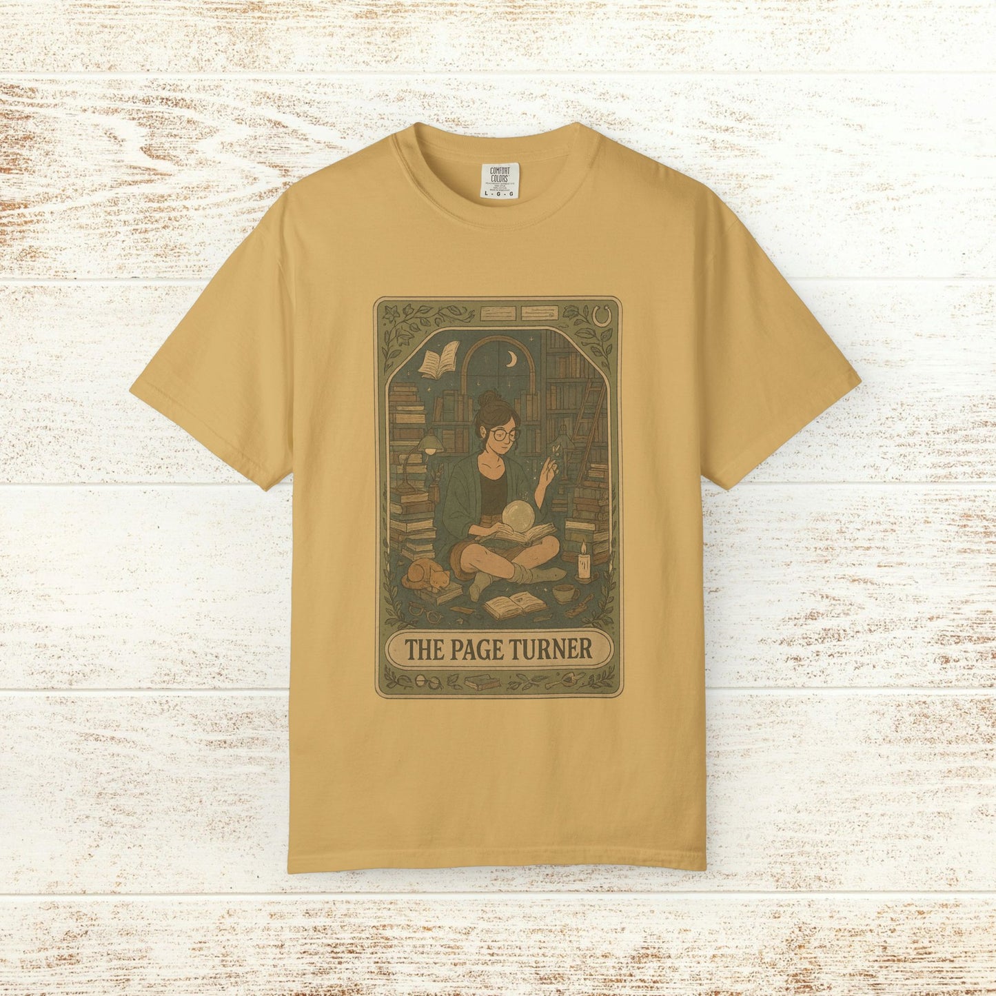 Page Turner Tarot Tee - Soft Cotton T-Shirt in warm yellow, highlighting a charming depiction of a reader surrounded by books, a great choice for tarot and literature lovers.