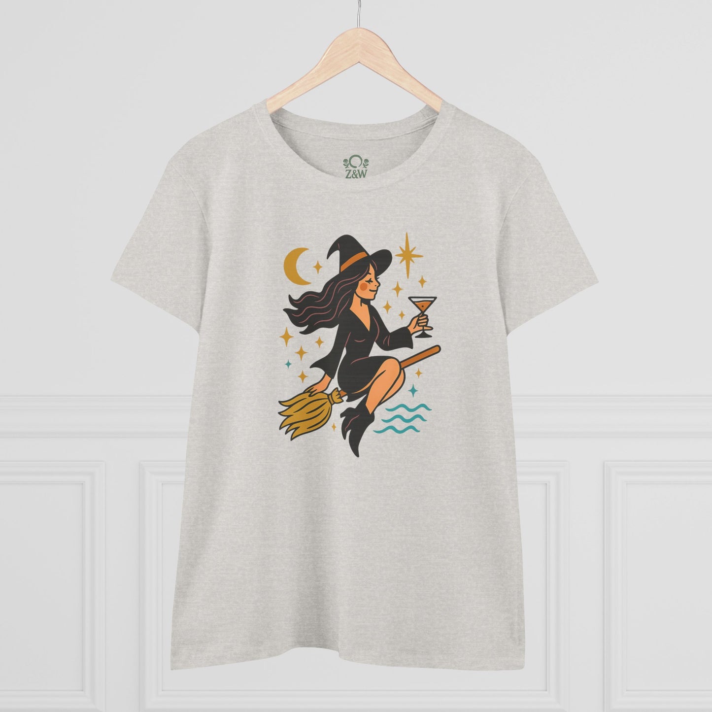 Witchy Night Out Tee featuring a stylish witch flying on a broomstick with a cocktail, crafted from 100% cotton for comfort and durability.