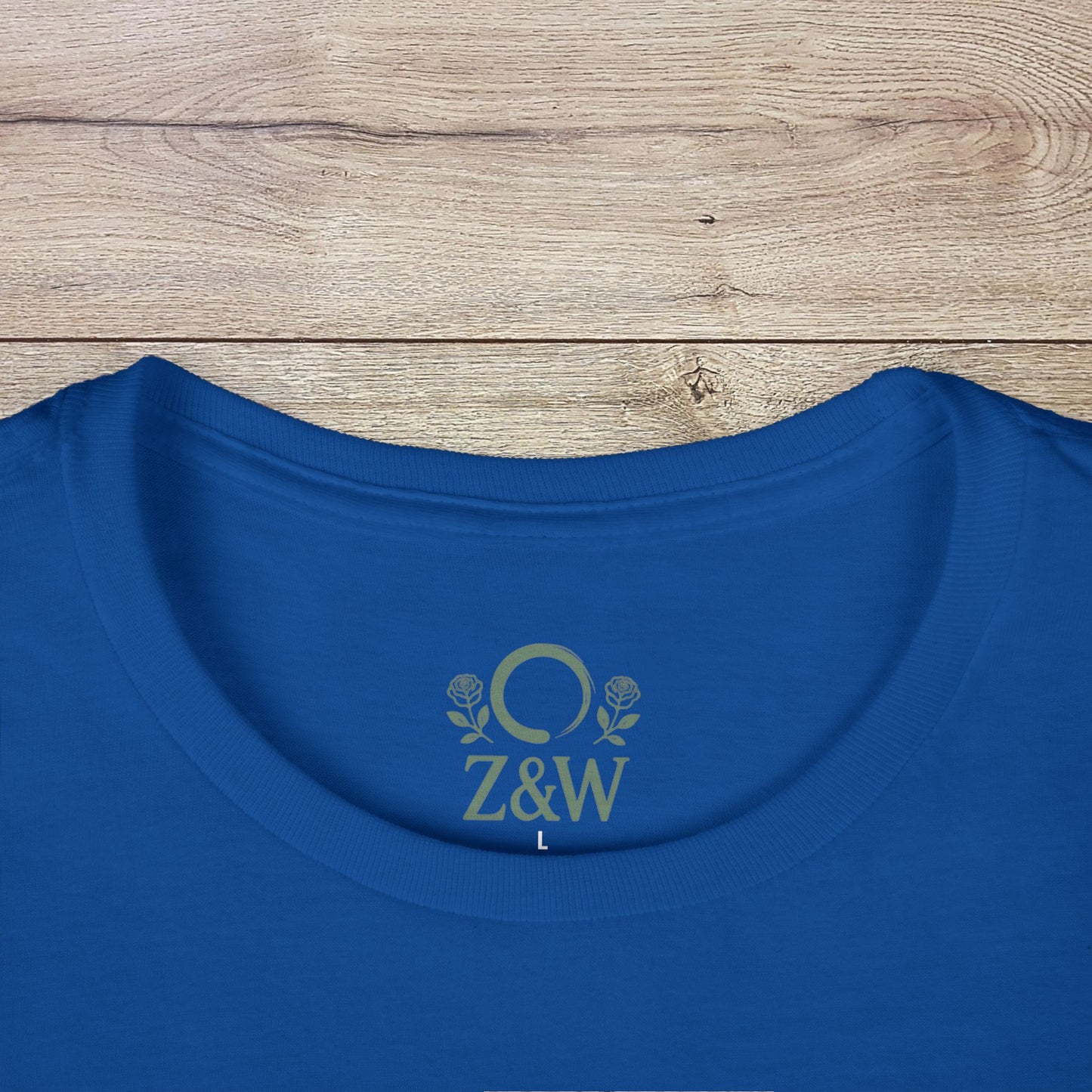 Wildflowers T-Shirt with a ribbed collar displayed on a wooden surface, showcasing its unique logo on the back and smooth fabric texture.