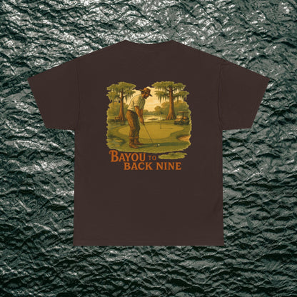 Bayou To Back Nine Softstyle Golf Tee on a dark brown t-shirt, depicting a golfer in action, designed for comfort and relaxed outings.