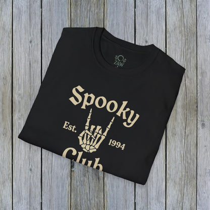 Folded Unisex Spooky Club Tee on a wooden surface, showcasing the skeleton hand design and 'Spooky Club Est. 1994' text. Made from soft, durable 100% cotton, ideal for Halloween celebrations.