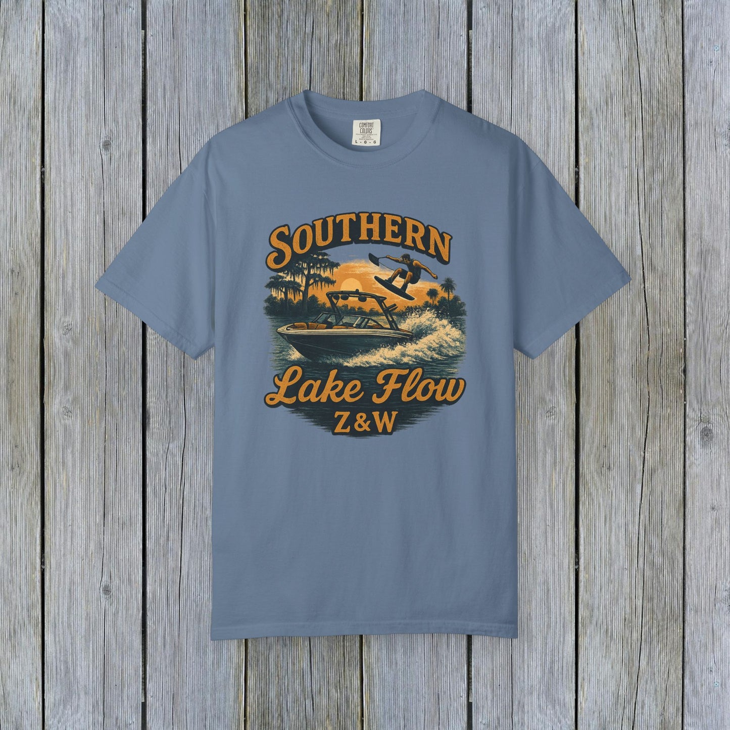 Southern Lake Flow T-Shirt in slate blue, designed with a retro graphic depicting lake sport activities, made from 100% US cotton that's both durable and stylish for eco-conscious consumers.