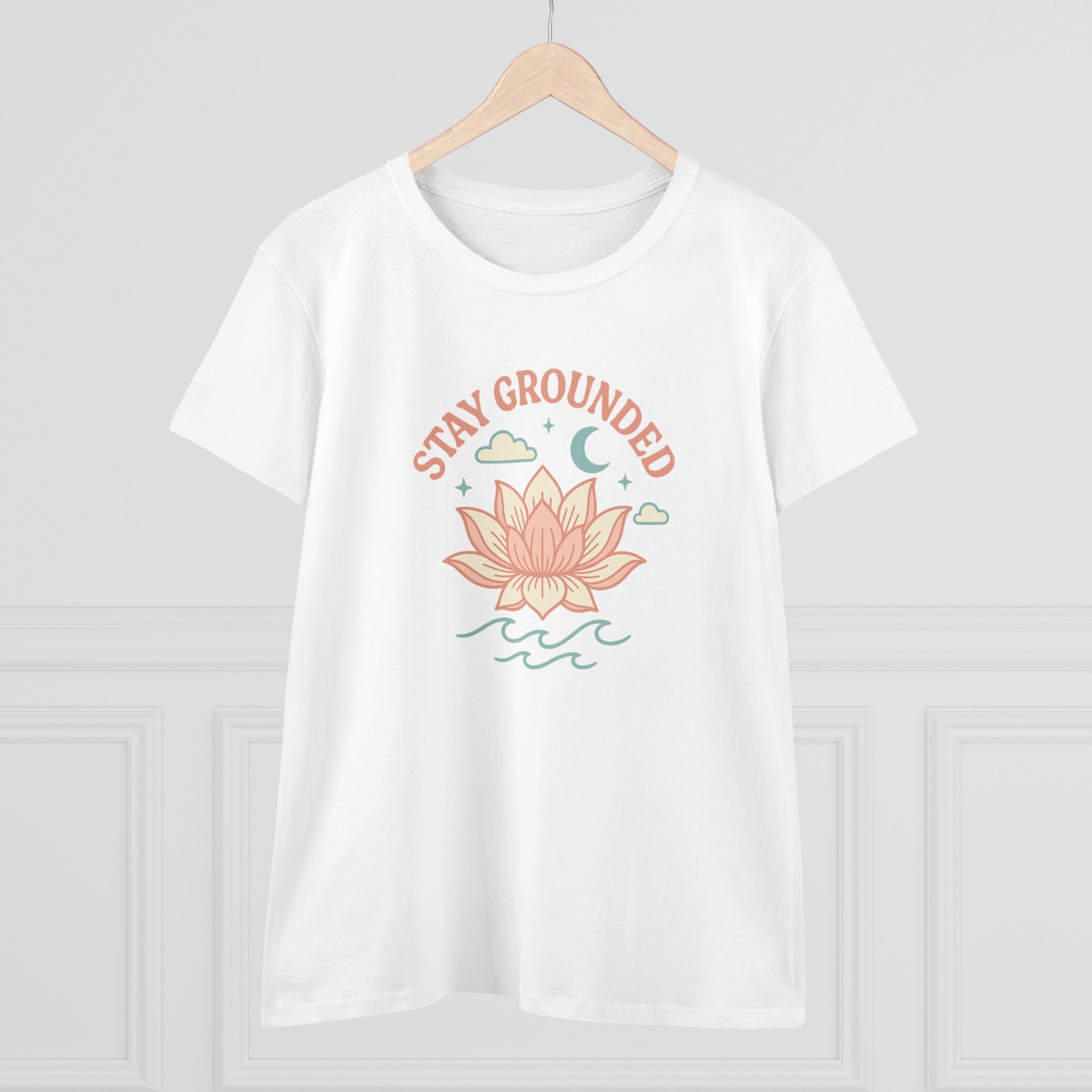 Stay Grounded Spiritual Tee displayed on a hanger, featuring a beautiful lotus illustration on a classic white crop top, ideal for warm days.