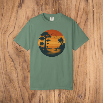 Unisex Garment-Dyed Sunset Tee in soft green showcasing a sunset graphic with palm silhouettes, great for everyday comfort.