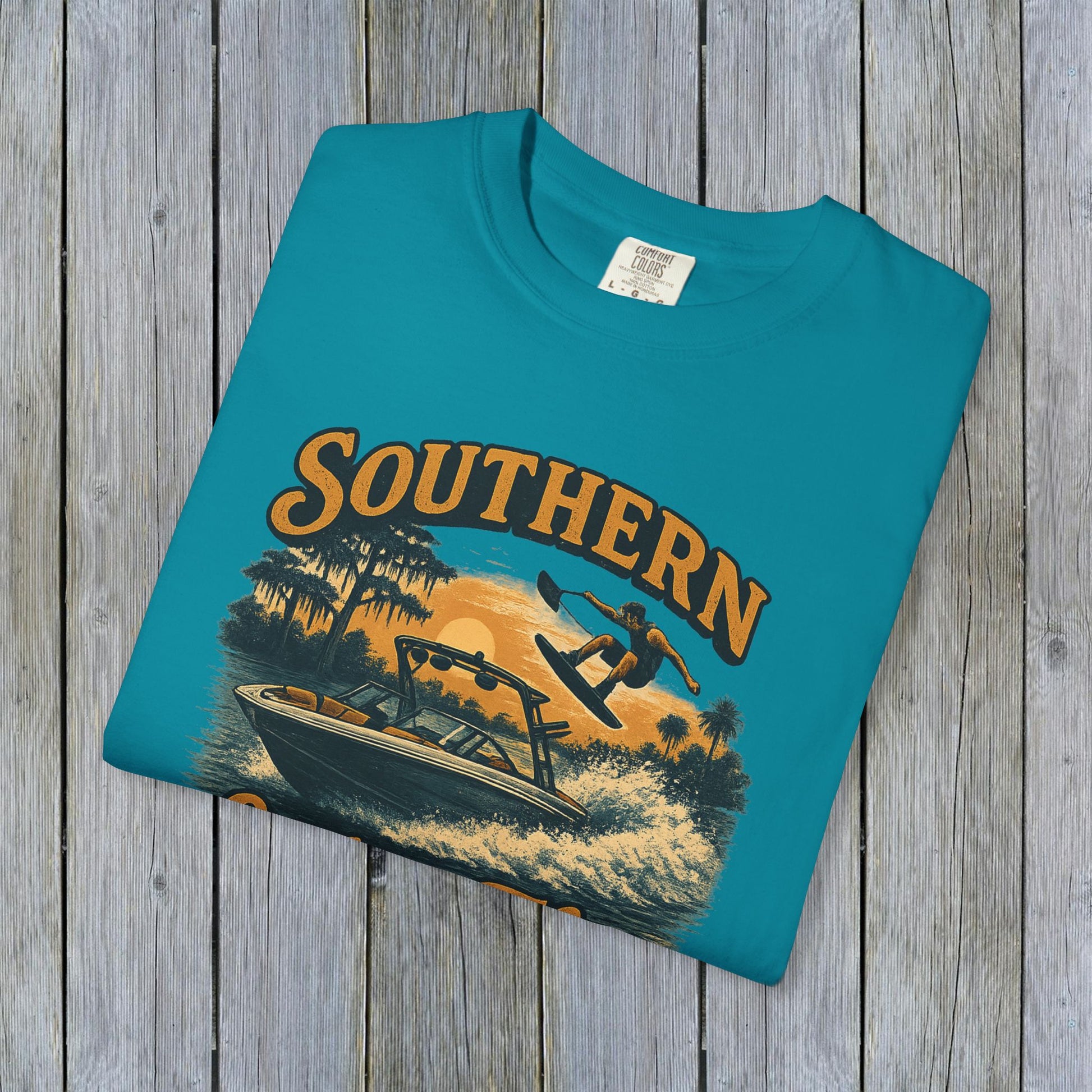 Flat lay of Southern Lake Flow T-Shirt in bright blue, made from 100% US cotton, featuring a vintage design with a wakeboarding theme.