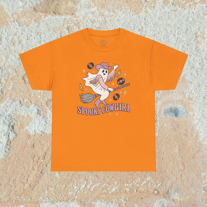 Vibrant orange Spooky Cowgirl graphic tee featuring a playful ghost with musical records and a broomstick, perfect for Halloween enthusiasts. Sizes available from S to 5XL.