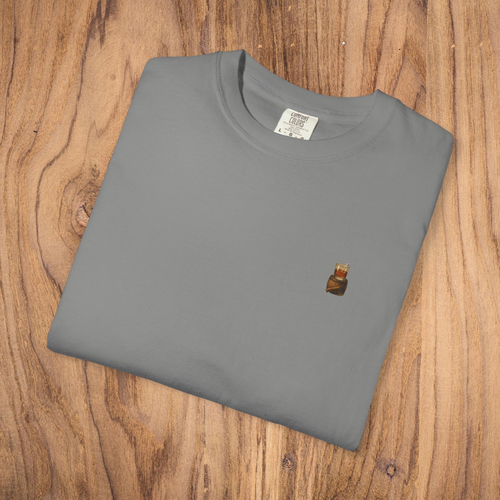 Premium Southern Made T-Shirt folded on wooden surface in grey, featuring a small logo, ideal for casual fashion. Available in multiple sizes.
