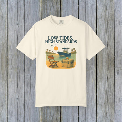 Garment-Dyed Low Tides High Standards T-Shirt in cream, showcasing an artistic beachfront design with a chair and boat. Crafted from soft 100% US cotton, offered in sizes S-4XL for a comfortable fit.
