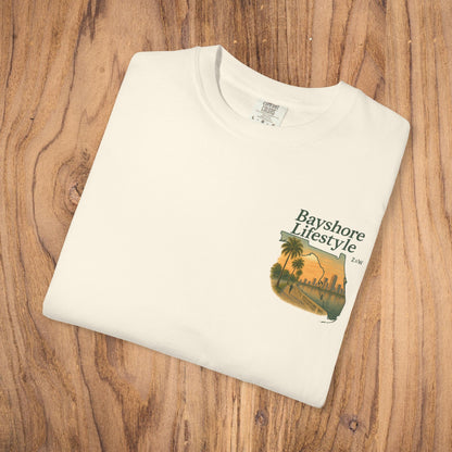 Bayshore Lifestyle Tee - Folded white t-shirt featuring a graphic design, laid out on a wooden surface.