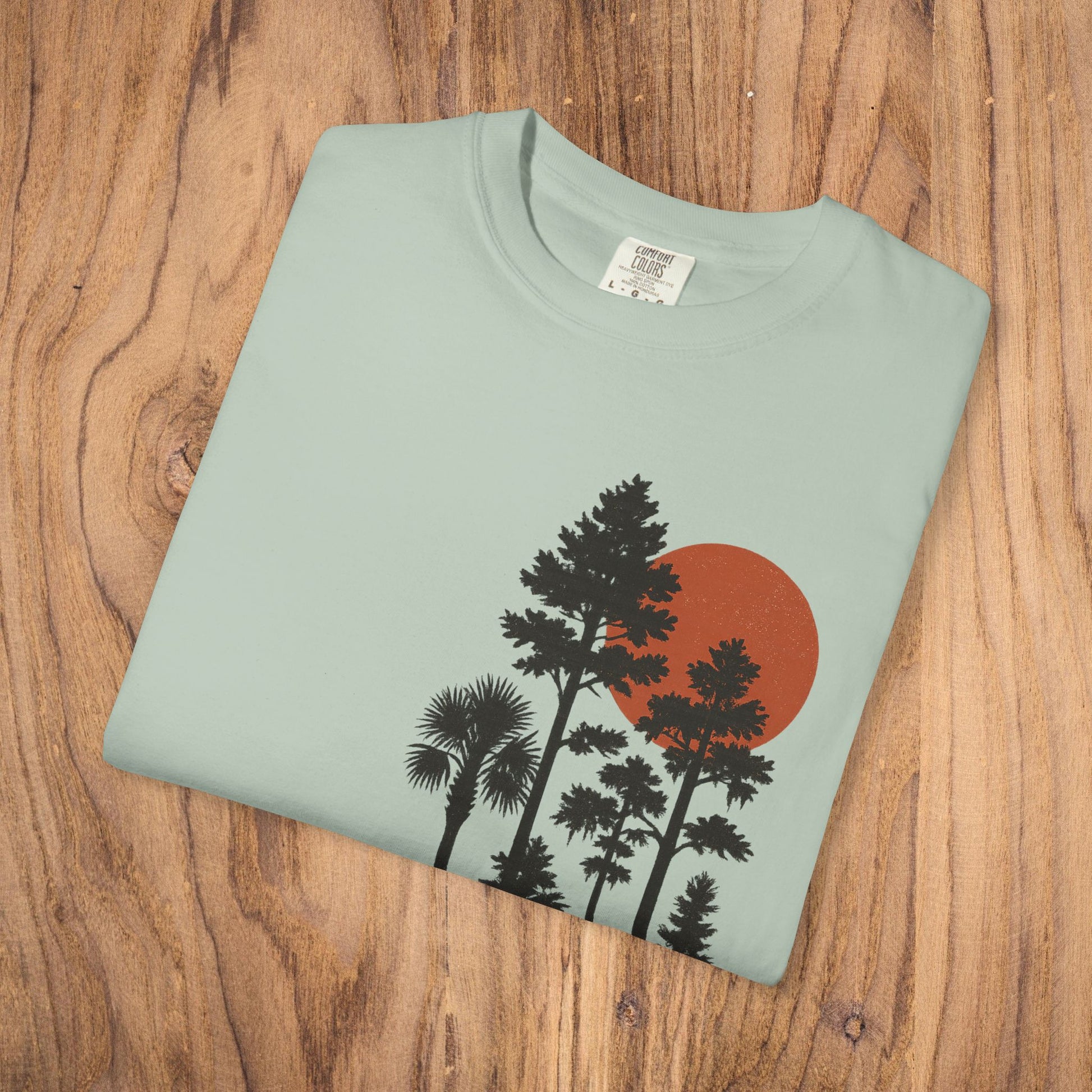 Folded view of the Sunset Trees Unisex T-Shirt in a light color, featuring a striking sunset and tree design, perfect for stylish casual wear.