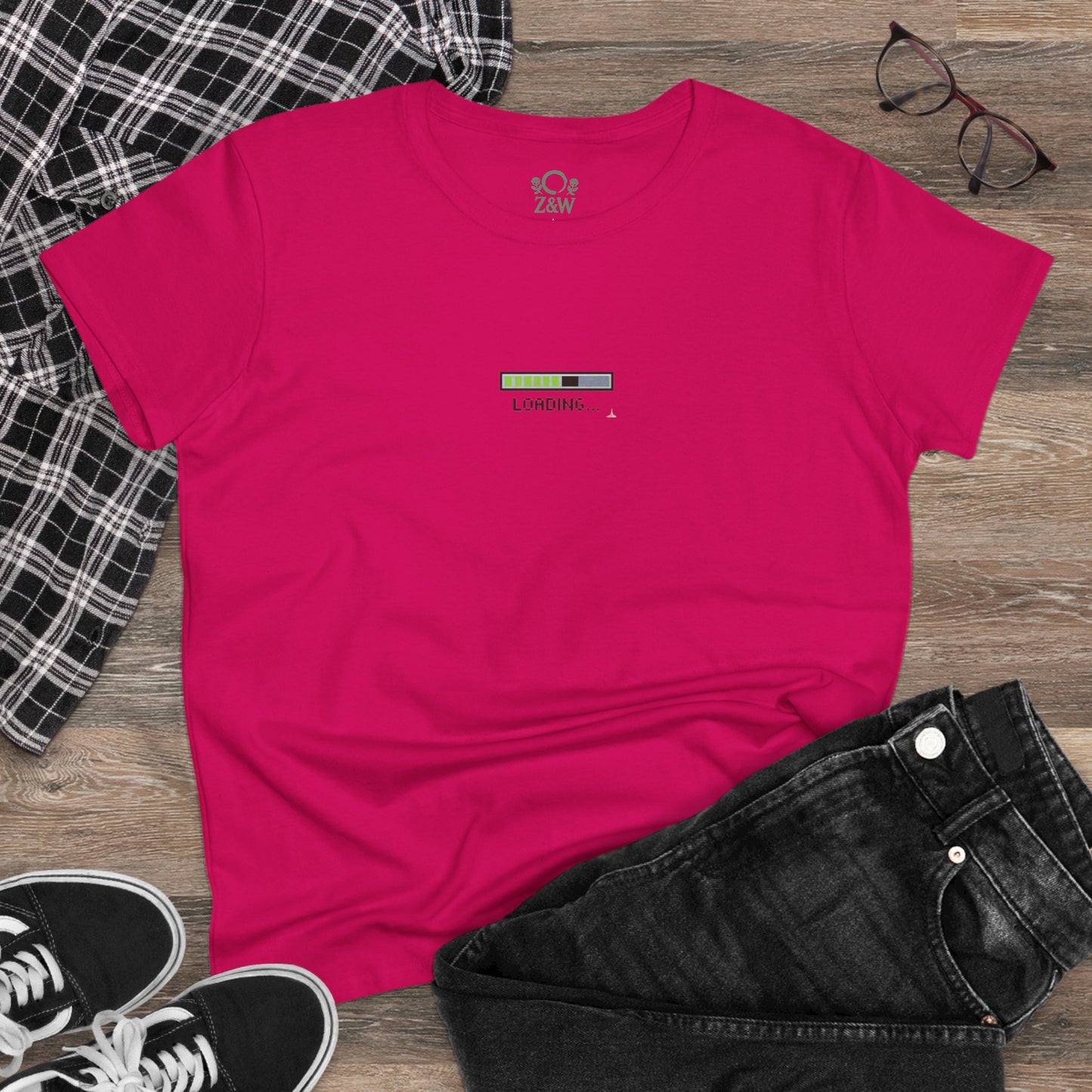 404 Y2K Graphic T-Shirt laid out on a wooden background, showing the pink design with a 'loading' graphic, paired with casual black jeans for a trendy outfit.