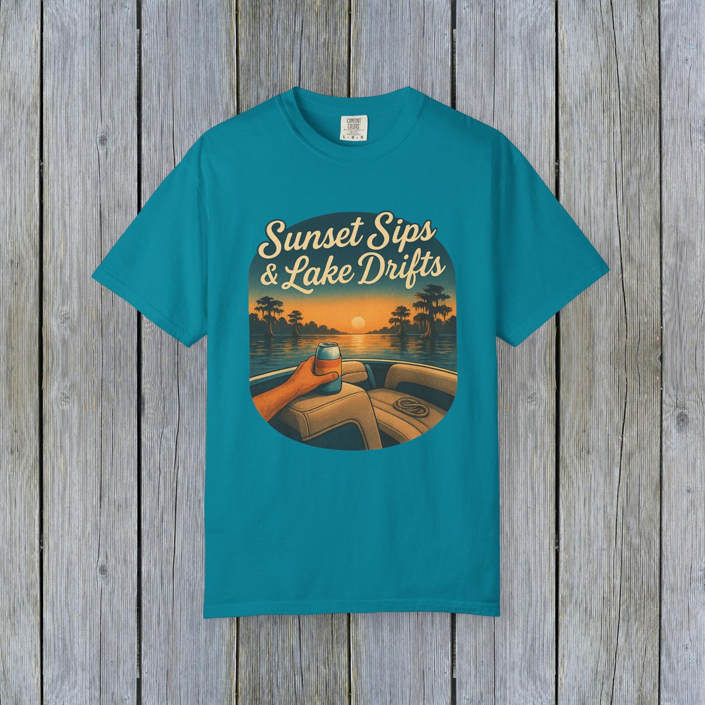 Lake Drifts T-Shirt in vibrant teal showcasing a scenic sunset design with a drink, ideal for warm weather relaxation.