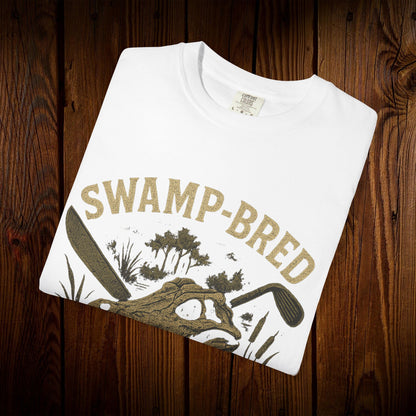 Close-up of the folded Unisex Swamp-Bred Fairway-Fed Tee in white, featuring the artistic alligator illustration, perfect for those who appreciate unique fashion.