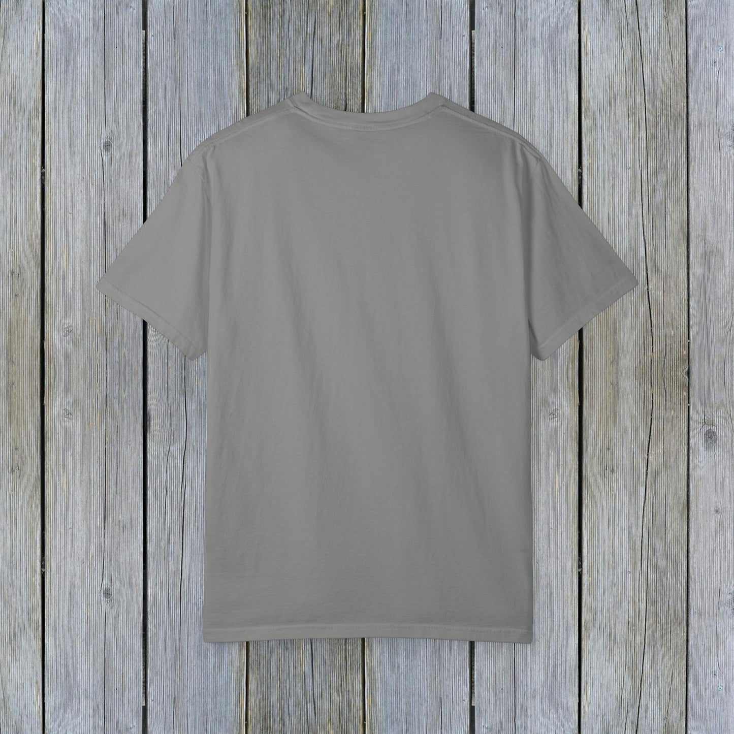 Back view of the Unisex Garment-Dyed Lake Rules Tee, showcasing its classic and relaxed design on a wooden background.