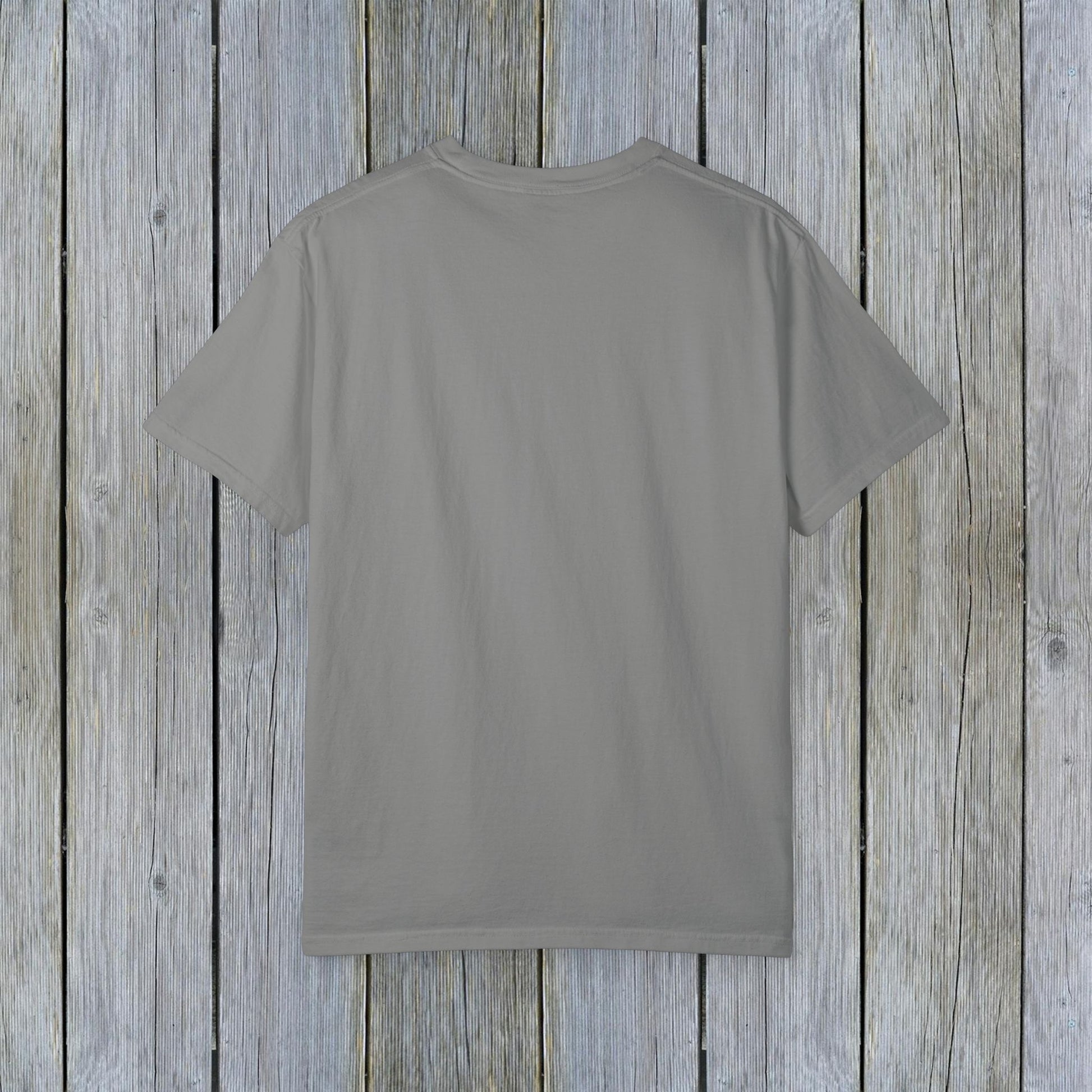 Back view of the Unisex Garment-Dyed Lake Rules Tee, showcasing its classic and relaxed design on a wooden background.