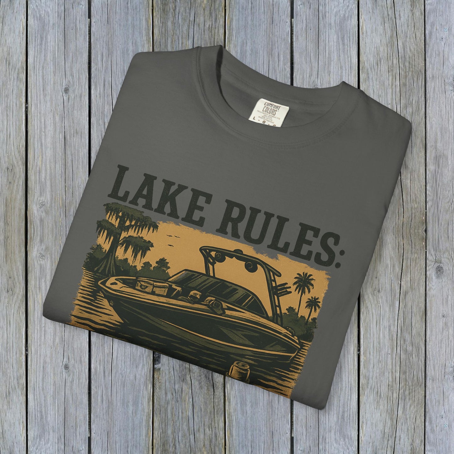 Unisex Garment-Dyed Lake Rules Tee displayed flat, featuring a vintage boat graphic and the words 'LAKE RULES:' in bold print, perfect for casual outdoor wear.