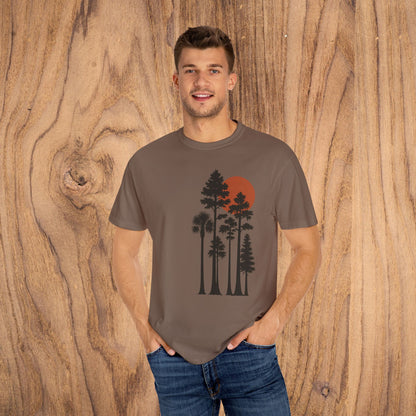 Sunset Trees Unisex T-Shirt modeled in brown, featuring a vibrant sunset and tree graphic, perfect for casual wear.
