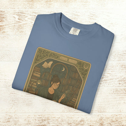 Page Turner Tarot Tee in sky blue featuring an artistic design of a book enthusiast, made from soft cotton, available in sizes S to 4XL, eco-friendly and comfortable.