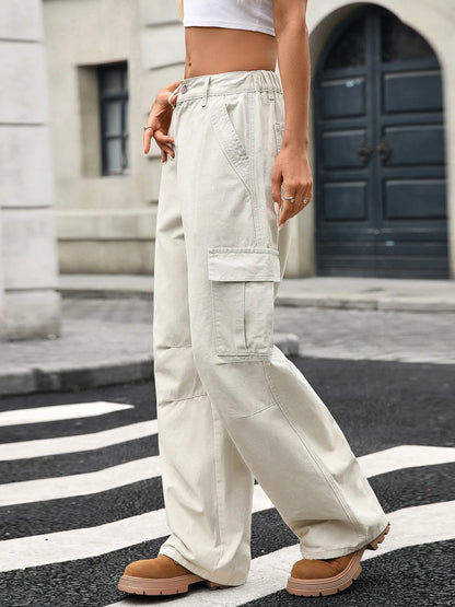 Close-up side view of a model in Wide Leg Cargo Jeans, showcasing the fabric texture and cargo style, complemented by a casual outfit and city surroundings.