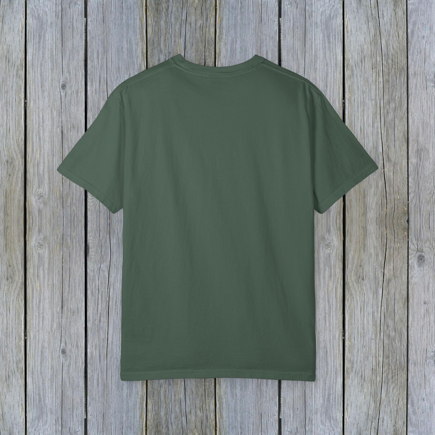 Back view of Unisex Garment-Dyed Lake Rules Tee in earthy green, perfect for outdoor adventures, presented against a textured wooden background.
