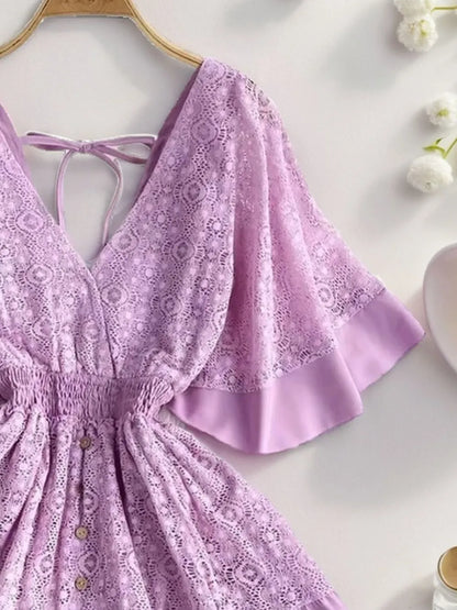 Semi-Sheer Ruffle Hem Lace Mini Dress With Tie Back featuring an elegant smocked design, showcasing delicate lace details and a stylish tie-back design in a soft lavender color.