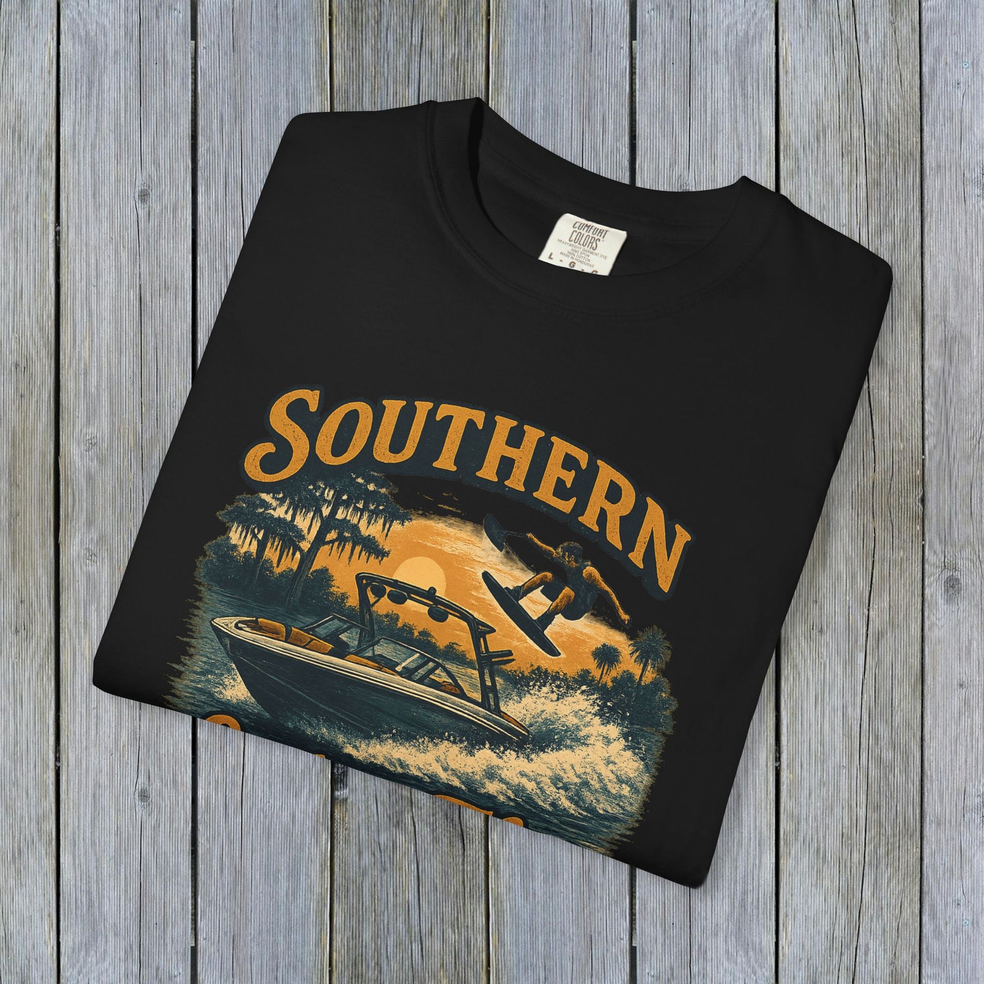 Folded Southern Lake Flow T-Shirt in black, made from 100% US cotton, emphasizing durability and eco-friendliness. Perfect for lake lovers and casual outings.