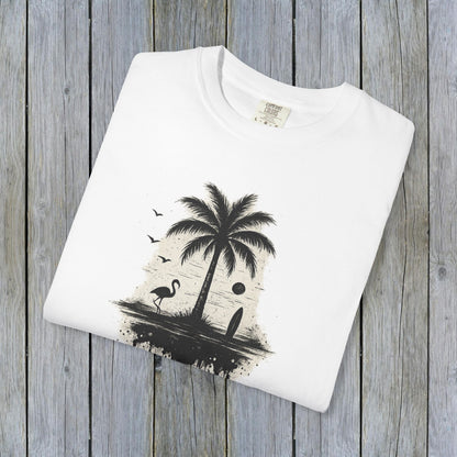 Tropical Sunset Graphic Tee displayed on a wooden background, showcasing a vibrant palm tree and flamingo design. Made from 100% cotton, available in sizes S-4XL for a comfortable fit.