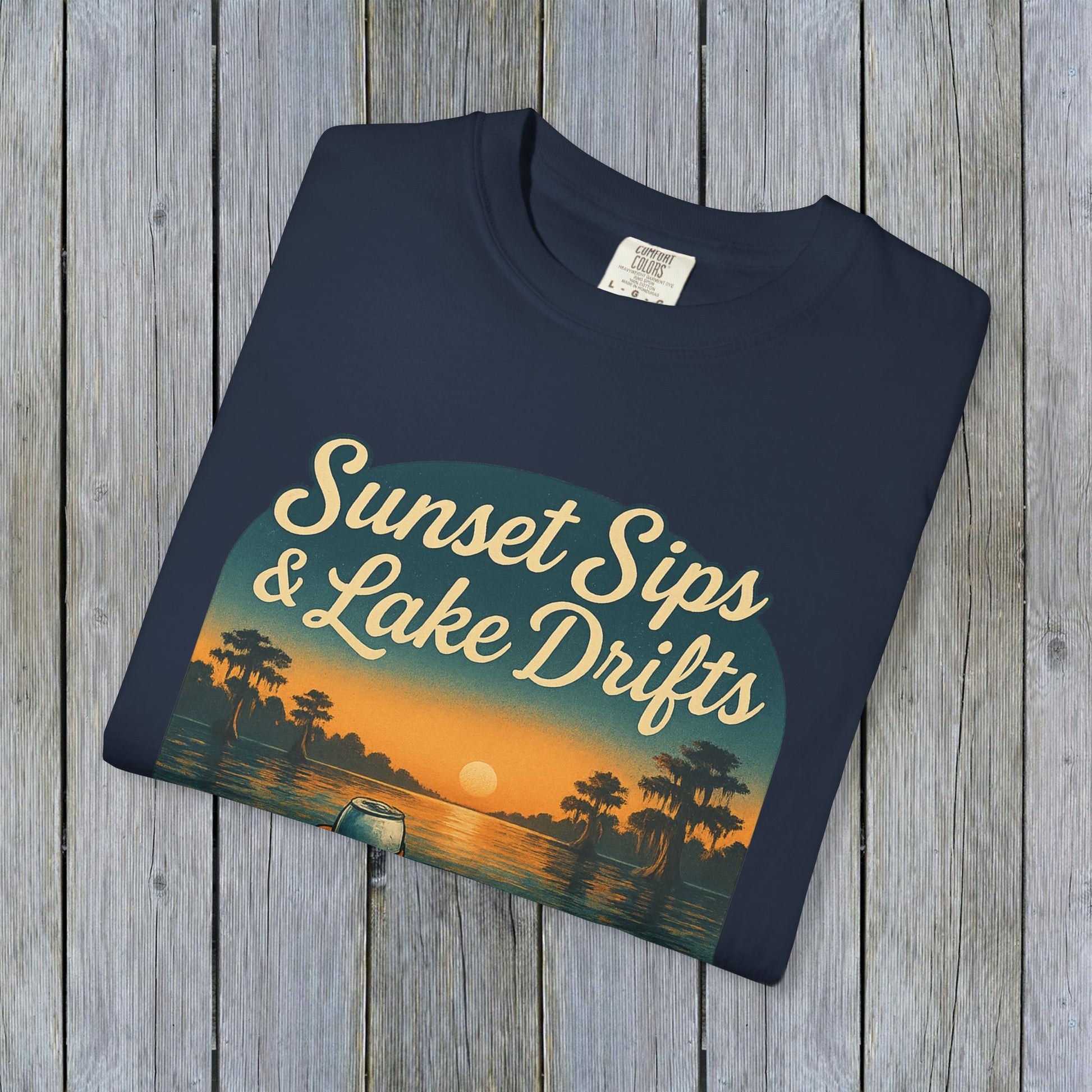 Folded Lake Drifts T-Shirt in navy blue showcasing an artistic sunset and lake graphic, perfect for casual wear or gifts.