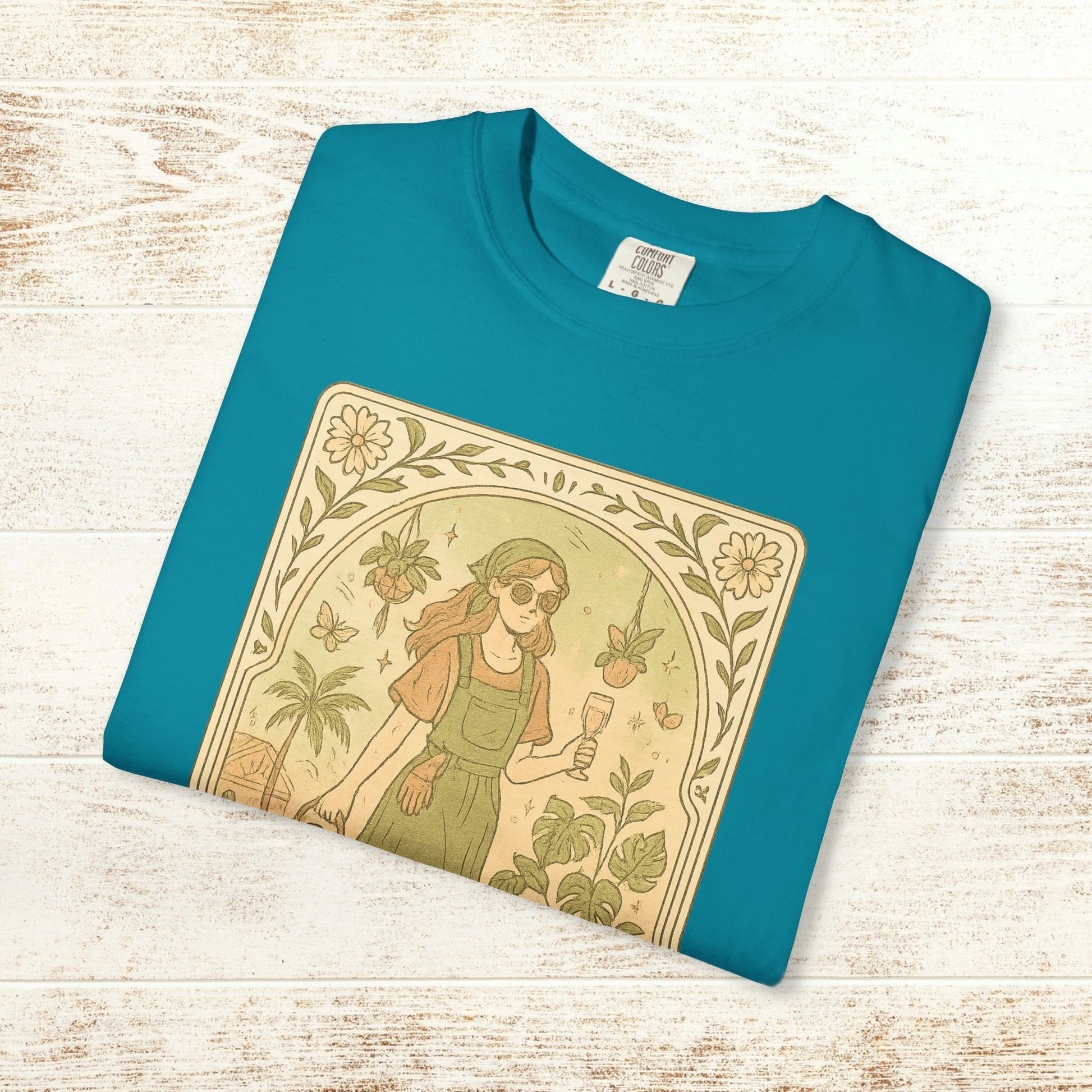 Rooted One Tarot Tee in vibrant teal displaying a charming illustration of a woman enjoying nature with plants and butterflies - crafted from ethically sourced cotton, sizes S-4XL.