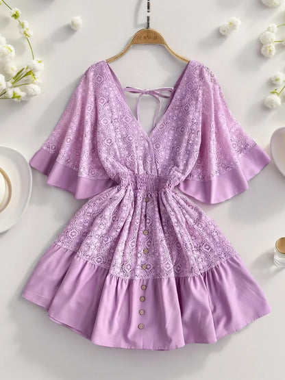 Flat lay image of a Semi-Sheer Ruffle Hem Lace Mini Dress with Tie Back - Elegant Smocked Design in a soft lavender shade, featuring ruffles and button accents, perfect for warm weather wear.