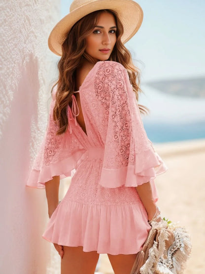 Back view of the Semi-Sheer Ruffle Hem Lace Mini Dress with Tie Back - Elegant Smocked Design, highlighted by a beautiful pink color and a tie-back feature, ideal for a chic beach look.