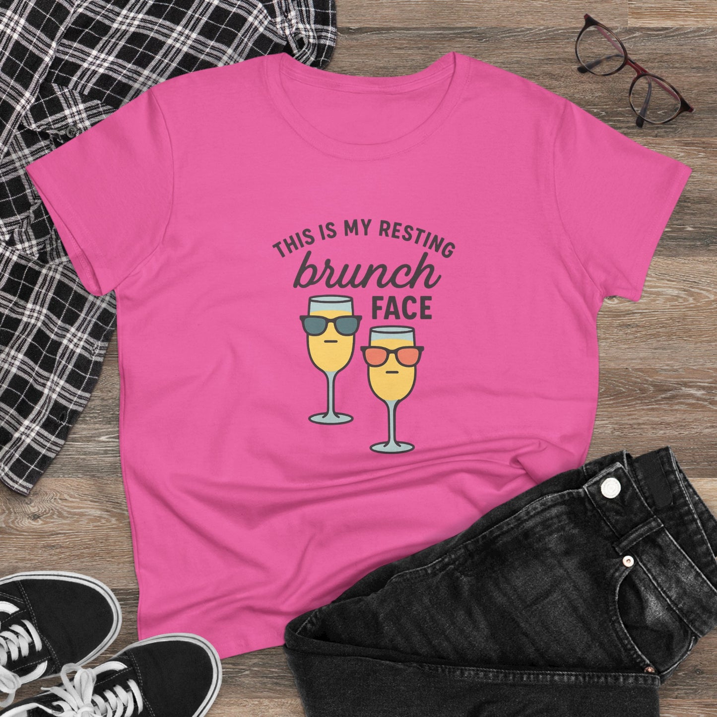 Stylish women's premium brunch face tee in pink, displayed with black shorts and plaid shirt, highlighting its comfortable cotton fabric.