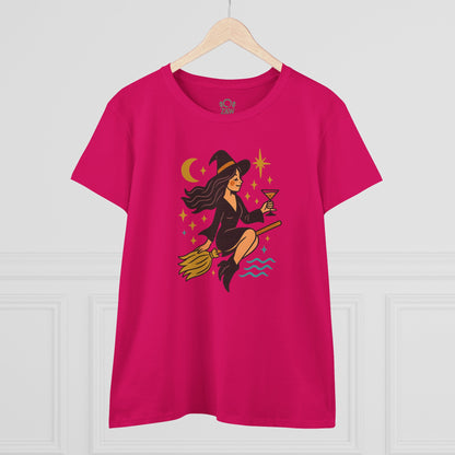 Witchy Night Out Tee featuring a stylish witch character holding a cocktail, designed for comfort and durability, displayed on a wooden hanger.