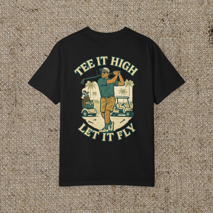 Tee It High Let It Fly Graphic Tee featuring a golfer swinging a club against a tropical background, perfect for golf enthusiasts.