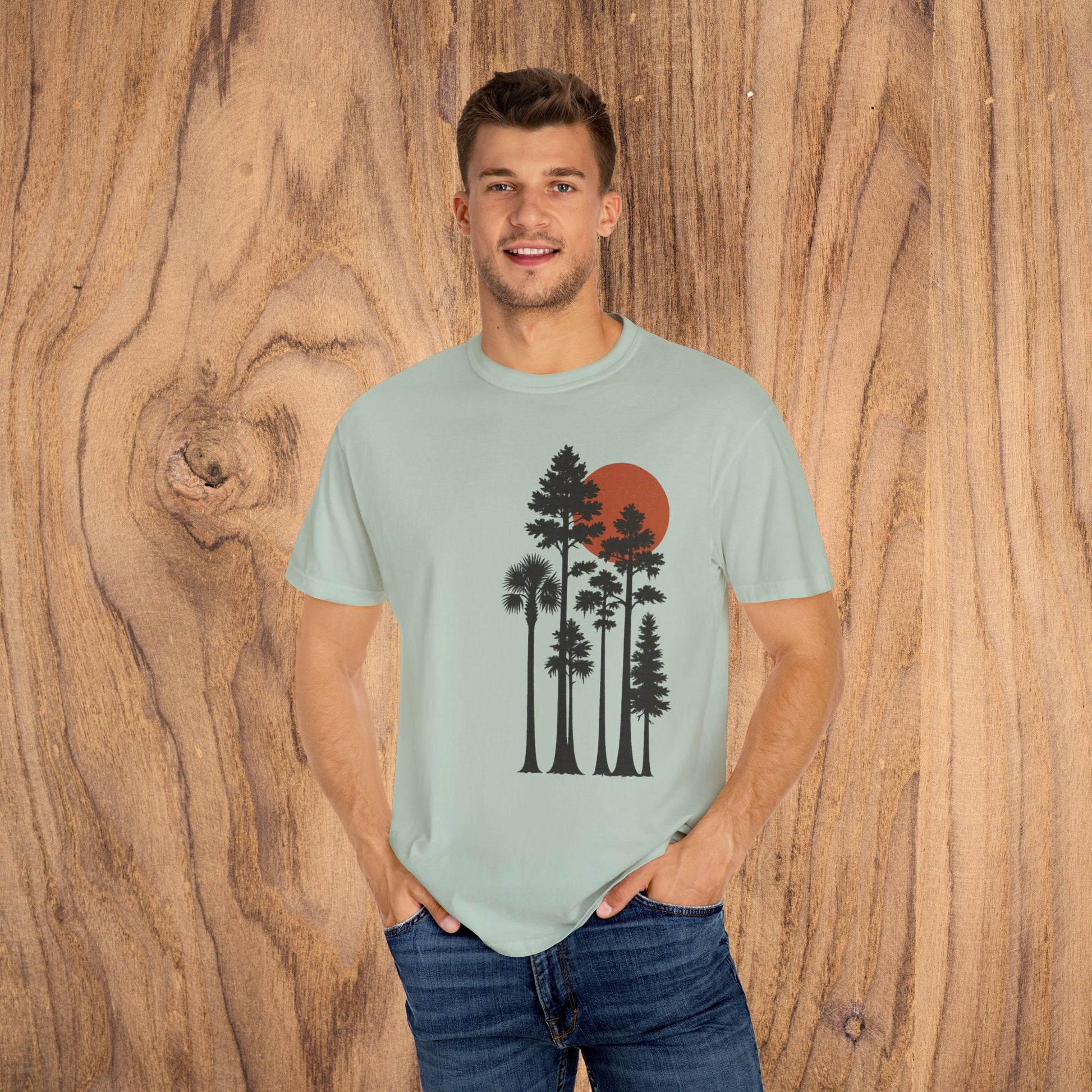 Sunset Trees Unisex T-Shirt displayed by a model, showcasing a soft 100% cotton garment-dyed design with a unique sunset and tree graphic.