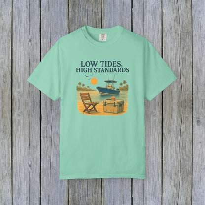 Garment-Dyed Low Tides High Standards T-Shirt in mint green. Features a beachy illustration depicting a chair and cooler next to a boat. Made from soft 100% US cotton, available in sizes S-4XL.